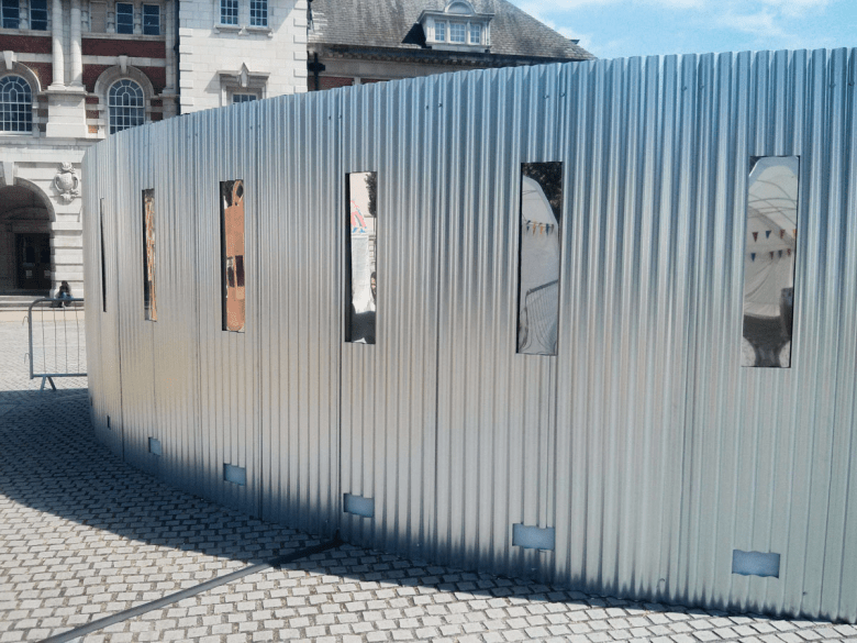 Anta Germane large scale public architectural artwork Interactive Tunnel showing curved shape and mirrored windows. Constructed from corrugated steel sheets, timber, one way persepx mirrors, PIR sensors and lights, situated in London Rootstein Hopkins Parade Ground.