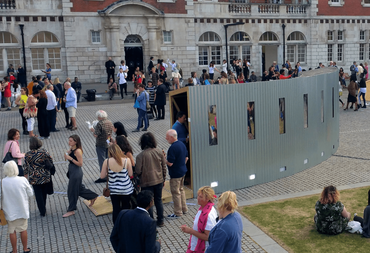 Anta Germane large scale public architectural artwork Interactive Tunnel showing curved shape and mirrored windows. Constructed from corrugated steel sheets, timber, one way persepx mirrors, PIR sensors and lights, situated in London Rootstein Hopkins Parade Ground.
