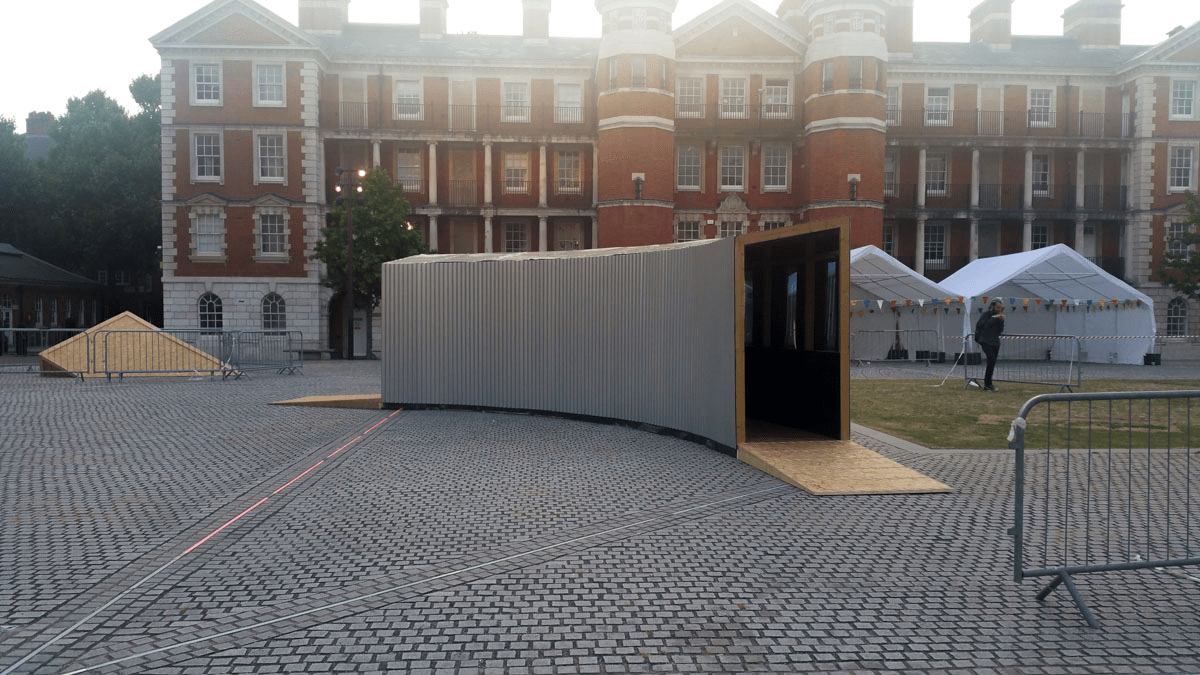 Anta Germane large scale public architectural artwork Interactive Tunnel showing back curve at full length at night. Constructed from corrugated steel sheets, timber, one way persepx mirrors, PIR sensors and lights, situated in London Rootstein Hopkins Parade Ground.