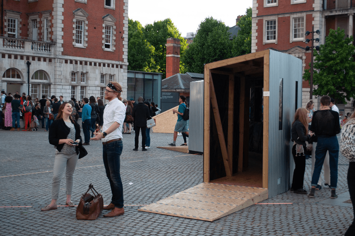 Anta Germane public artwork entrance during private view. Interactive Tunnel is constructed from steel sheets, timber, one way persepx mirrors, PIR sensors and lights, situated in London Rootstein Hopkins Parade Ground.